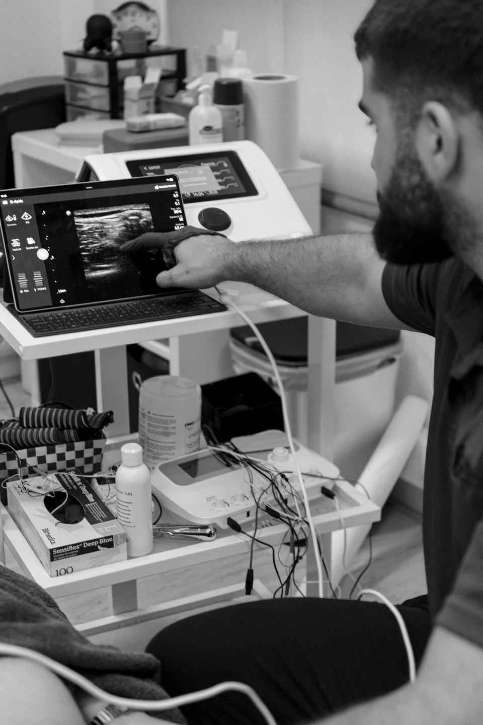 Ander Blanco señala una imagen ecográfica en la pantalla del ecógrafo; en blanco y negro